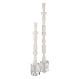 A set of two white sculptures with crystal feet, designed to resemble a stacked totem pole.