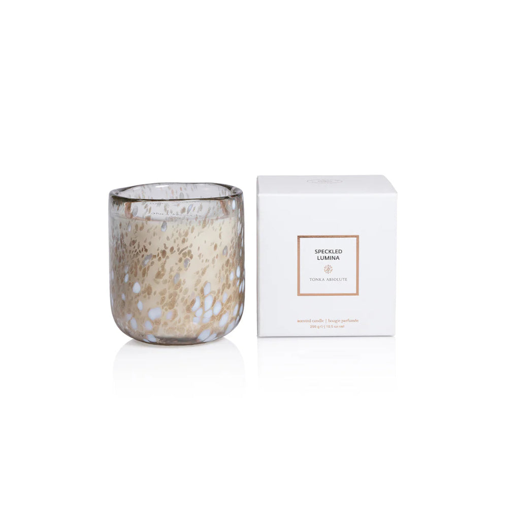 Speckled glass candle with a white box on a white background