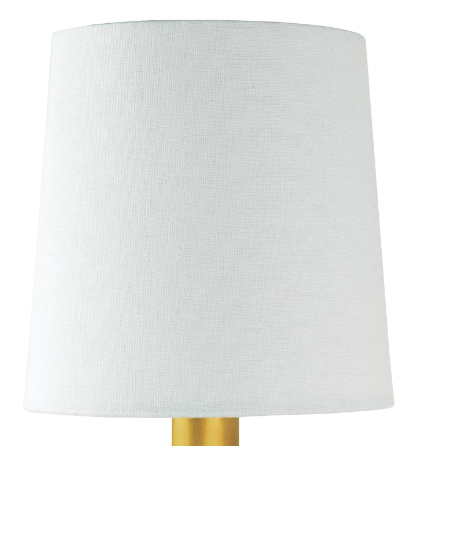 Brass and alabaster wall sconce with white shade on white wall.
