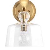Hudson gold wall sconce on white wall.