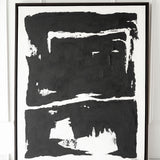 Solo black artwork on table with white wall behind