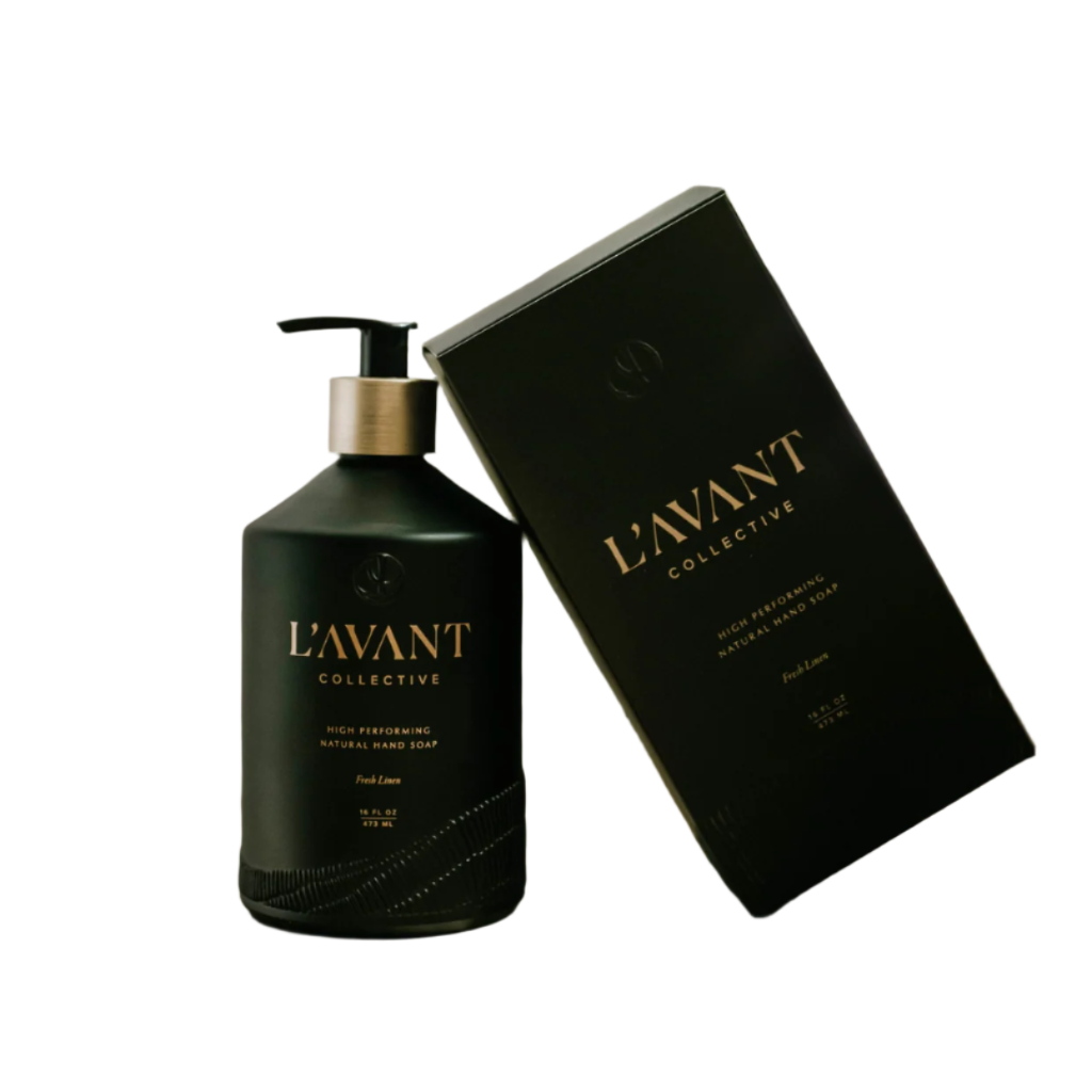 Black soap bottle and packaging with 'L'Avant Collective' branding on a wooden surface.