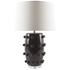 Black lamp with textured design and white shade on a white background