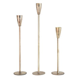 Three metallic candle holders of varying heights on a white background