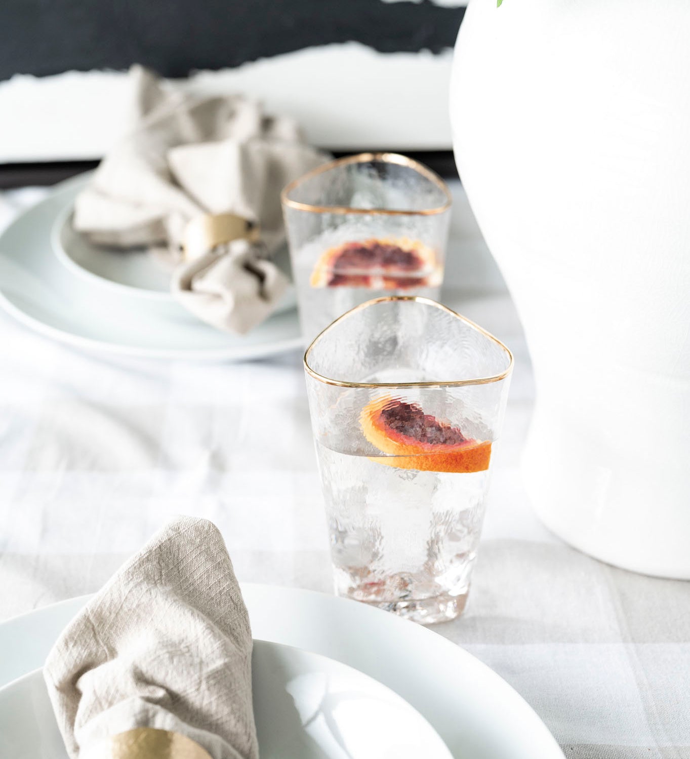 Aperitivo Triangular highball glass with gold rim styled with white dinnerware