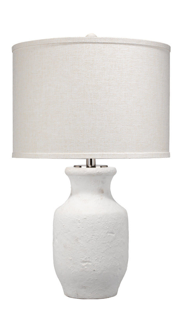 White cement table lamp with white wall behind.