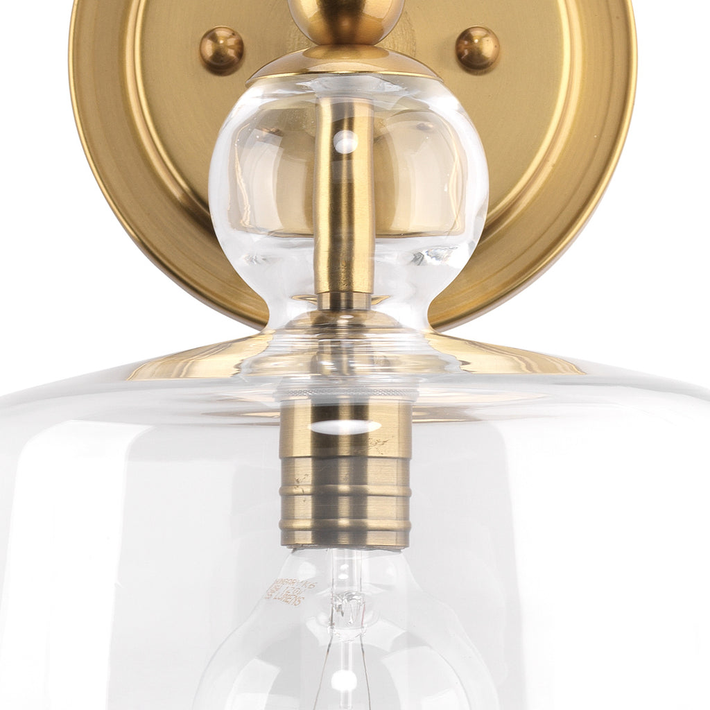 Hudson gold wall sconce on white wall.