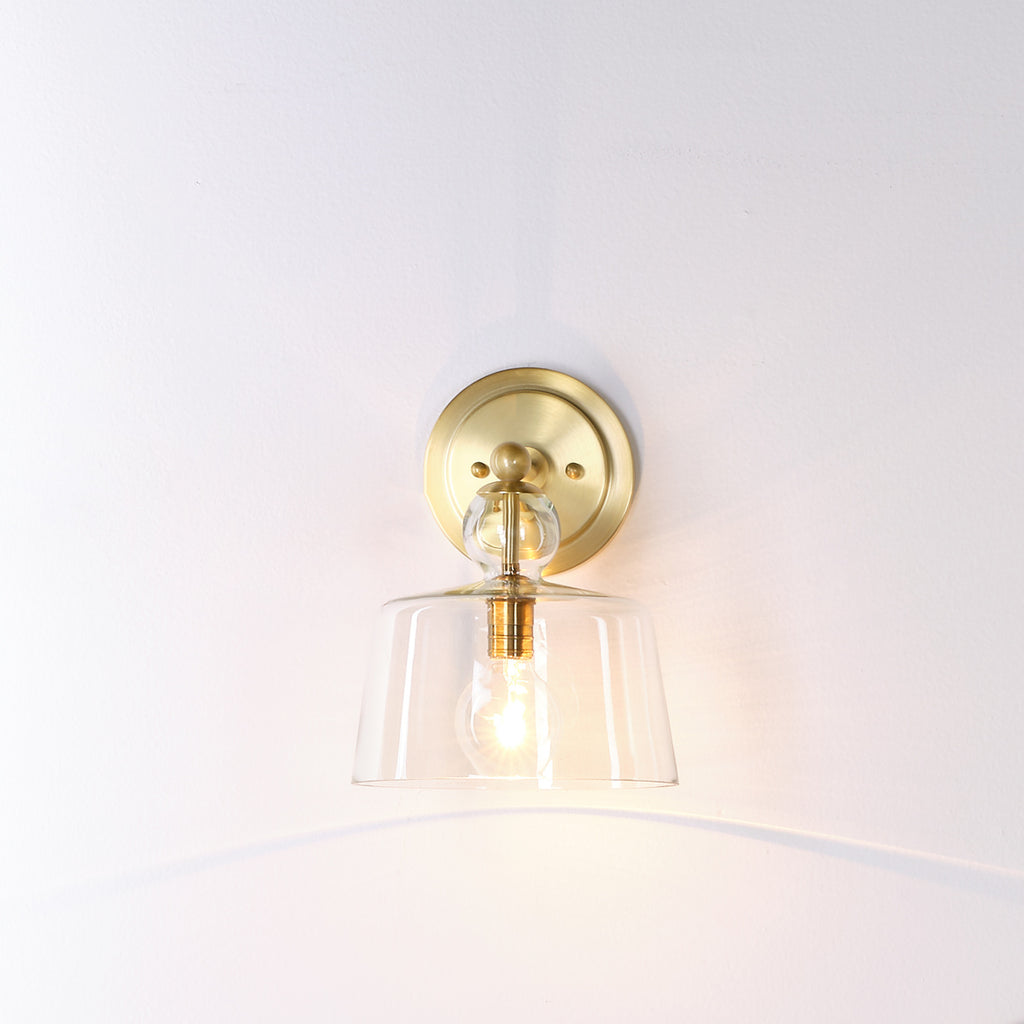 Hudson gold wall sconce on white wall.