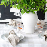 White oversized dishes on table with place settingsetting and black and white art behind