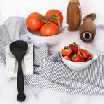 Black Dish Towel set next to bowls and spoon rest with white background