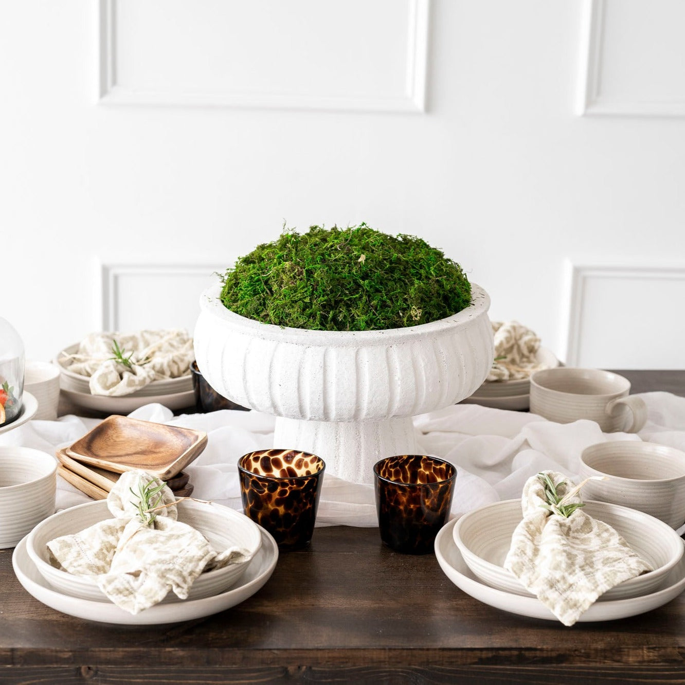 loft Reactive Glaze Blate with table setting on wood table with white wall behind