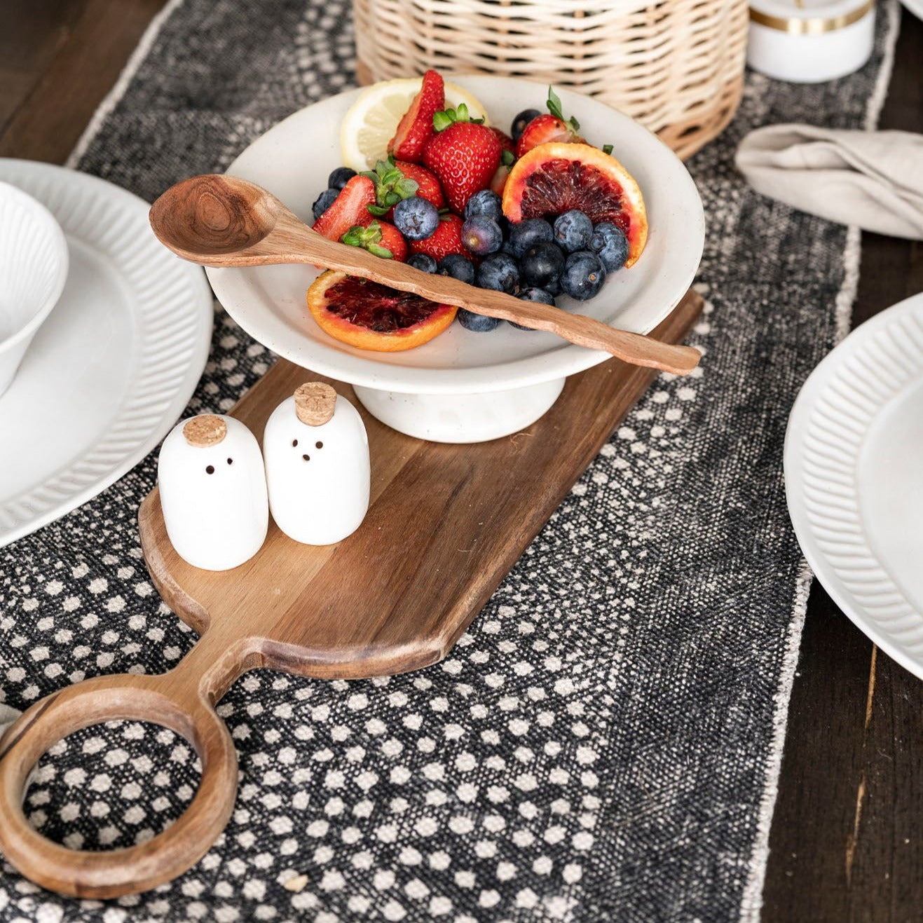 Table Runner with dot pattern on wood table with table setting and basket with black and white art behind