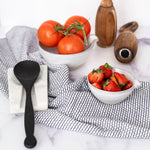 Marble Spoon Rest with black spoon and black and white towel with white background