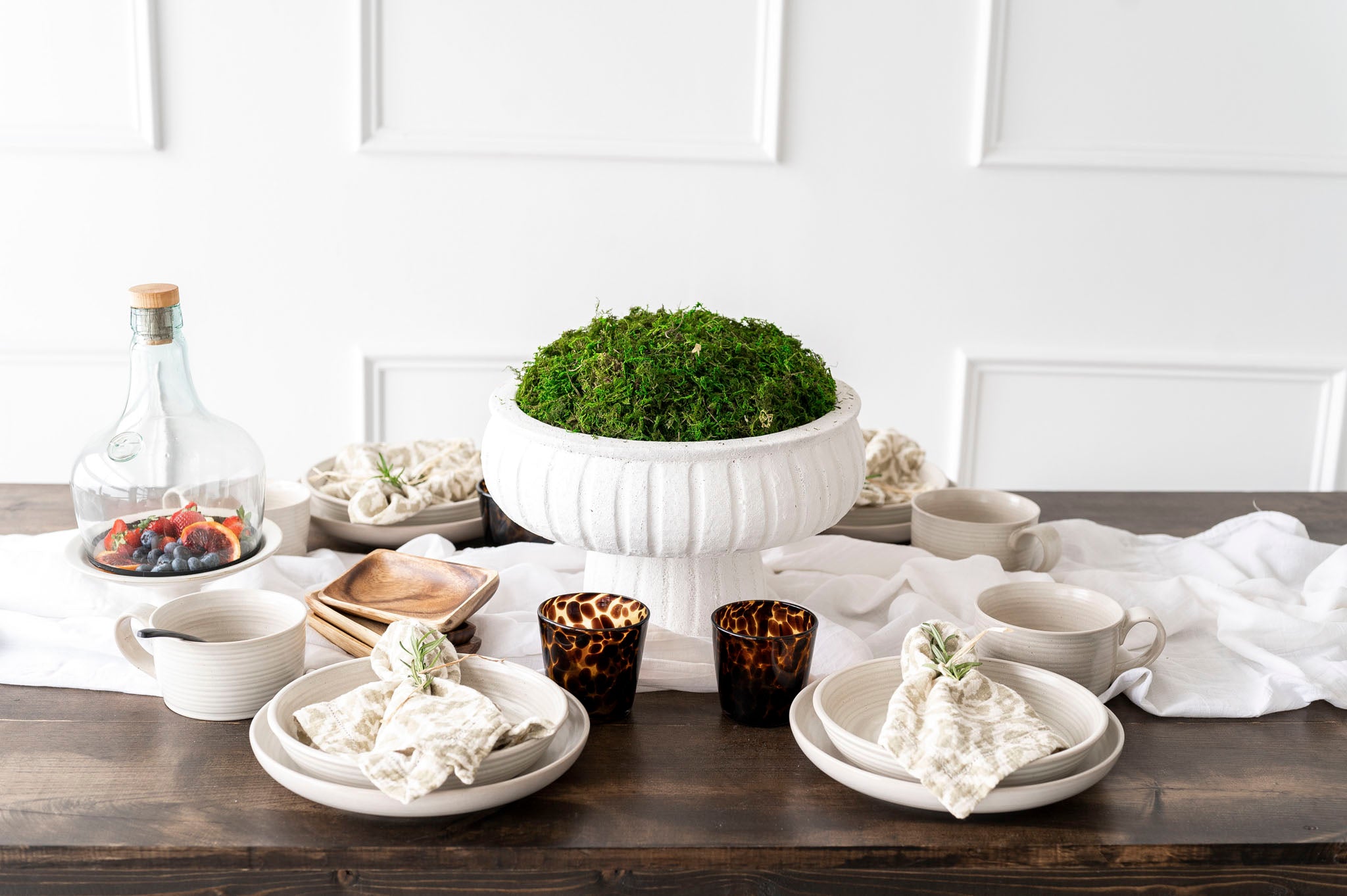 Shay Napkins on plates on wood table with white wall behind