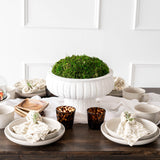 Shay Napkins on plates on wood table with white wall behind