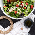 Rope trivet flatlay with salad and oil cruet