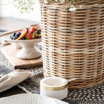 Wicker basket with flowers inside sitting on wood table