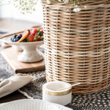 Wicker basket with flowers inside sitting on wood table