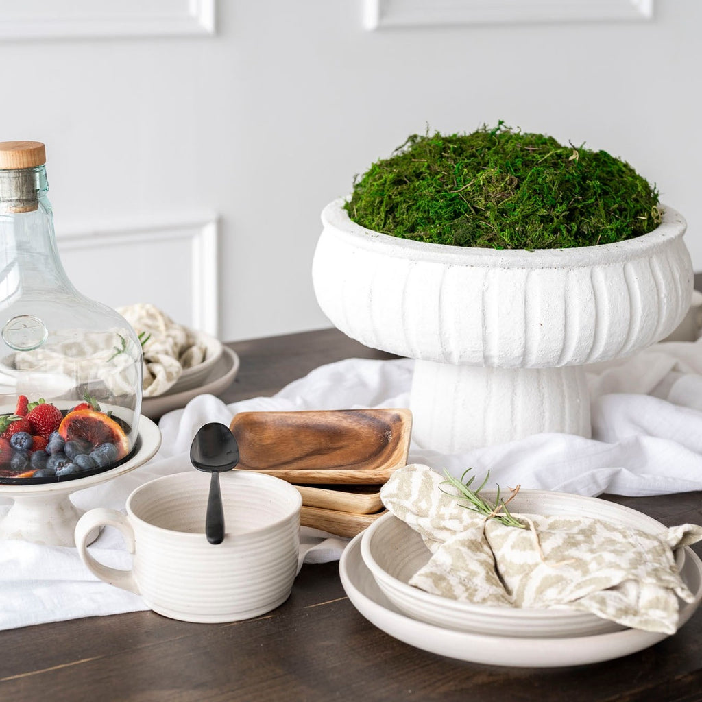 White Aegean Pedestal bowl with moss on table with white wall behind