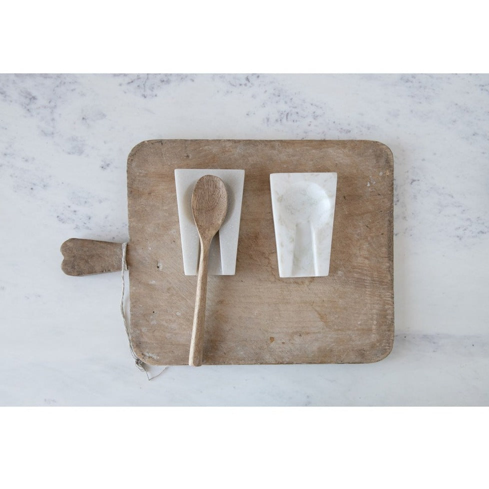white marble spoon rest on wood serving board white background