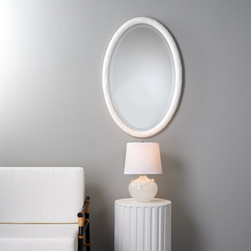 Ovation white oval mirror on wall in room.